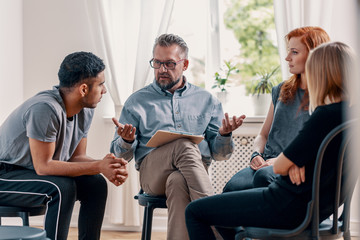 Counselor talking with rebellious teenagers with depression