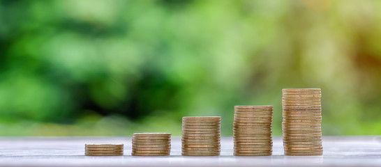 gold coins stack on wooden table in the morning sunlight. business, investment, retirement, finance...