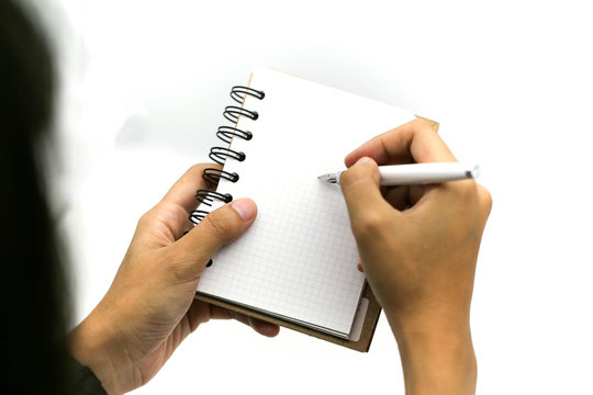 Hands write paper sheet or notebook and pen. White table. Top view