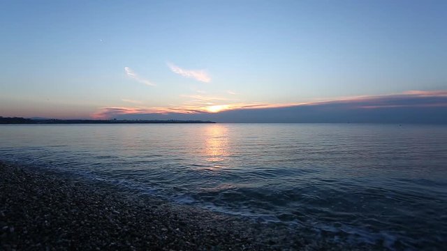 beach with calm sea and pebbles at the sunrise, Antalya, Turkey