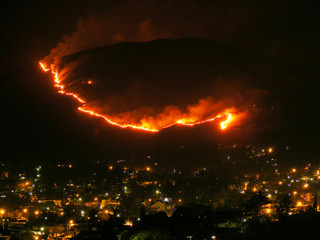 Fototapeta na wymiar Fire in the hills near the city, at night.