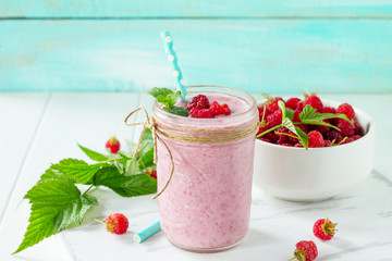 Raspberry milkshake or smoothie on a dark wooden table. Healthy juicy vitamin drink diet or vegan food concept. Copy space.