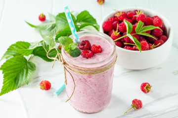 Raspberry milkshake or smoothie on a dark wooden table. Healthy juicy vitamin drink diet or vegan food concept.