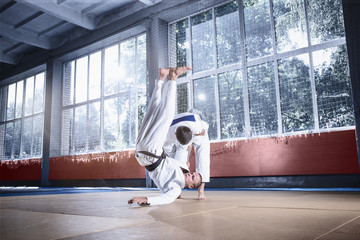 Two judo fighters showing technical skill while practicing martial arts in a fight club. The two...