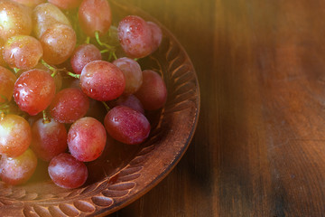 grape on brown plate on dark wooden background with copy space. Close Up