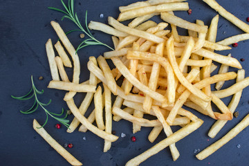 French fries on on black stone plate, top view