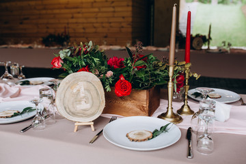 a wedding table with cutlery, candles and flowers.