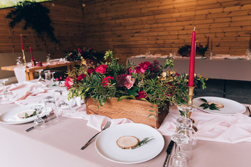 a wedding table with cutlery, candles and flowers.