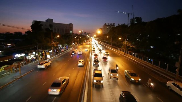 4k of traffic on Ngamwongwan Road with sunset at Kasetsart University in bangkok, Thailand