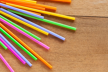 Colorful Straw on wood table background.