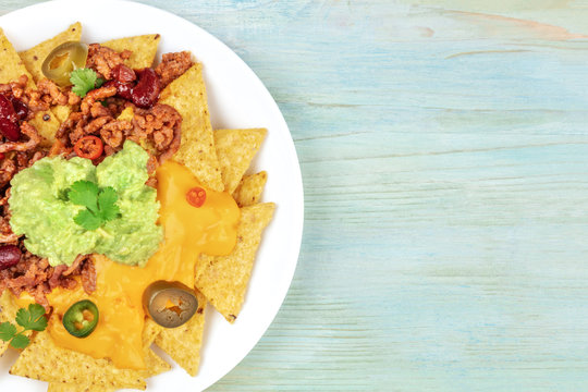 Closeup of nachos with cheese and chilli, traditional Mexican snack, with copyspace