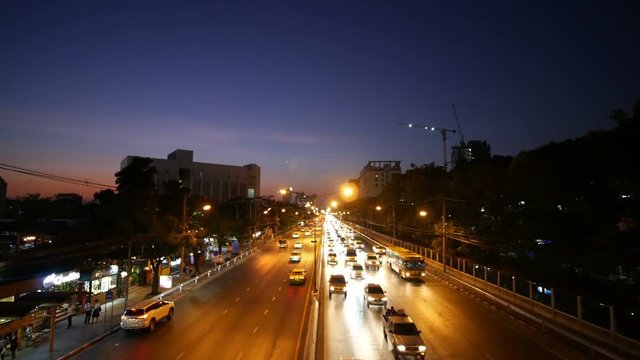 4k of traffic on Ngamwongwan Road with sunset at Kasetsart University in bangkok, Thailand