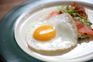 Zucchini fritters with egg and smoked salmon on wood background vinage style