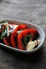 Fresh basil cheese and tomatoes Caprese Salad on wood background in mystic light