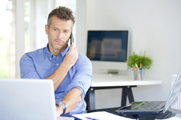 Businessman with mobile phone and notebook in the office