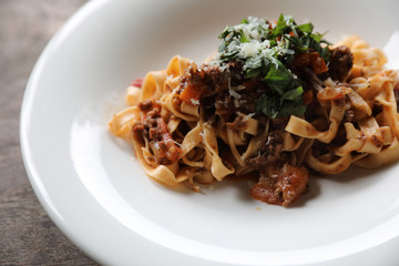 Pasta Fettuccine Bolognese with beef and tomato sauce on wood background in dark tone mystic light style