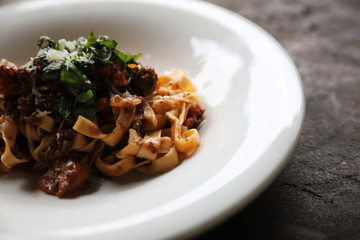 Pasta Fettuccine Bolognese with beef and tomato sauce on wood background in dark tone mystic light style
