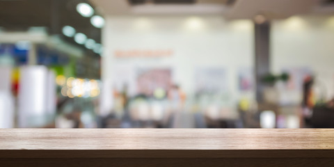 Empty wooden table top with blurred store background.