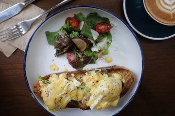 Egg benedict , poached eggs with toast and coffee on wood background , English Breakfast top view