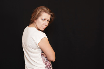 A middle-aged woman with an angry face on a black background