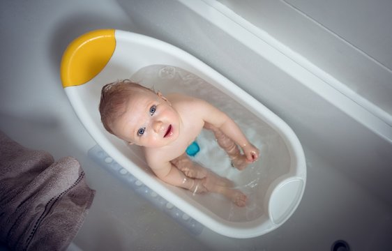 Overhead view of baby girl taking bath in bathtub