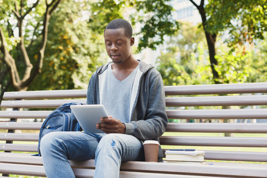 Serious african-american student with tablet in the park oudoors