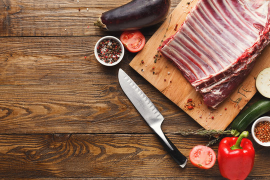 Raw rack of lamb on wooden board