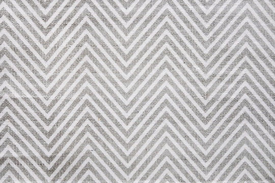 Chevron patterned carpet rug runner in white and gray. Close up