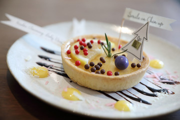 Lemon tart pie topping with chocolate ball sweet dessert on wood background