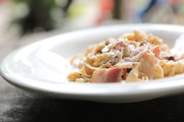Pasta white sauce with bacon and mushroom on wood background in mystic light
