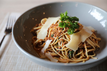 spaghetti Bolognese with minced beef and tomato sauce garnished with parmesan cheese and basil , Italian food