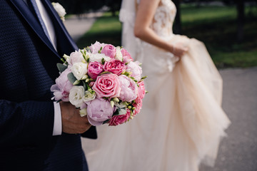 wedding pink bouquet in the groom hands