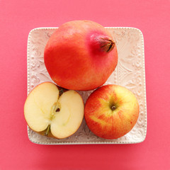 Rosh hashanah (jewish New Year holiday) concept. Pomegranate and apple raditional symbols. Flat lay.