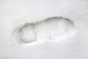 Foot step of winter boot in deep white cold snow arctic hiking