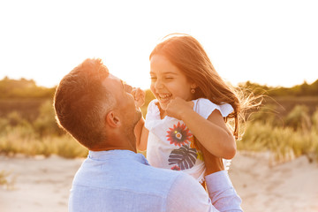 Cute family having fun together outdoors at the beach.