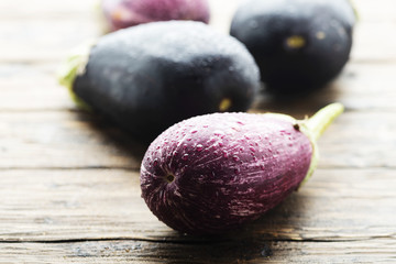 Fresh aubergines on the wooden table, selective focus