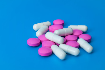 A pile of large pills of pink and white color close-up.
