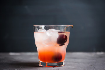Old fashioned cocktail with cherry. Selective focus.