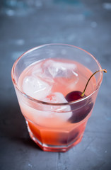 Old fashioned cocktail with cherry. Selective focus.