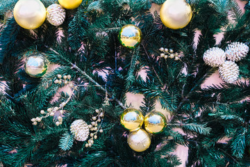 Obraz na płótnie Canvas background christmas tree decorated with golden balls and silver cones
