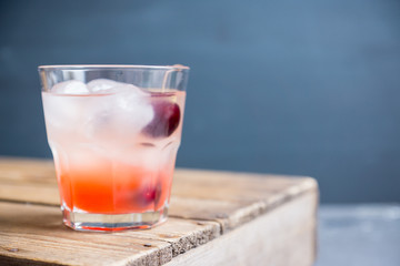 Old fashioned cocktail with cherry. Selective focus.
