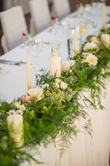 wedding table with exclusive floral arrangement prepared for reception, wedding or event centerpiece in greenery style