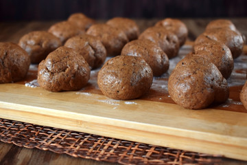 Formed balls of rye yeast dough are ready to be baked on a wooden board