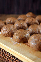 Formed balls of rye yeast dough are ready to be baked on a wooden board