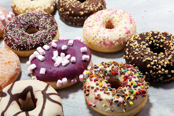 assorted donuts with chocolate frosted, pink glazed and sprinkles donuts