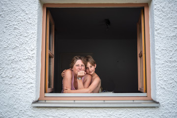 Portrait of woman with her son looking out the window smiling