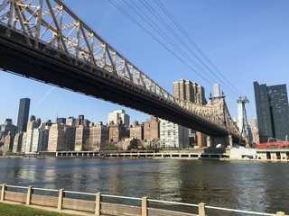 Fototapeta na wymiar Manhattan scape from the Roosevelt Island, New York City. The bridge over East river from Roosevelt Island to Manhattan. Wallpaper, background.
