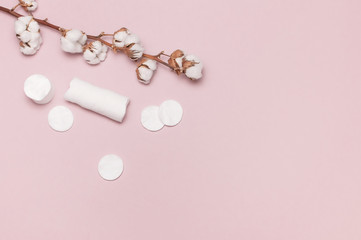 Spa concept. Flat lay background with cotton branch, cotton pads. Cotton Cosmetic Makeup Removers Tampons. Hygienic sanitary swabs on the pink background Top view with copy space