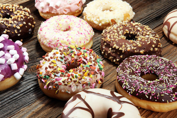 assorted donuts with chocolate frosted, pink glazed and sprinkles donuts