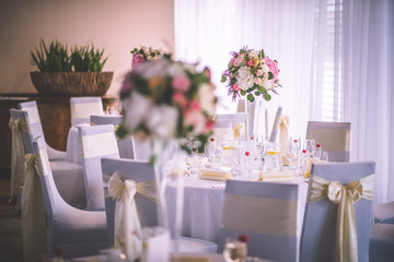 Wedding table with exclusive floral arrangement prepared for reception, wedding or event centerpiece in romantic pink style